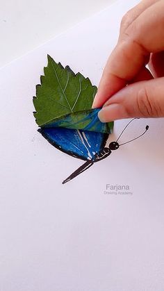 a person is drawing a butterfly with colored pencils