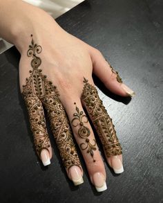 a woman's hand with henna tattoos on it