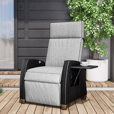 a gray chair sitting on top of a wooden floor next to a potted plant