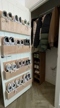 a closet with shoes and coats hanging on the wall