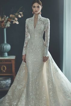 a woman in a wedding dress with long sleeves