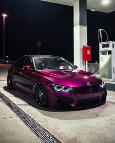 a purple car parked in front of a gas station