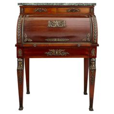 an old fashioned wooden desk with ornate carvings on the top and bottom drawers, inlaid to