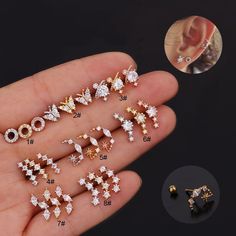 a hand holding several different types of ear studs