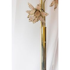 a tall brass flower lamp on a white background