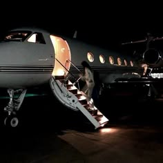 an airplane with stairs going up to the door and on top of it at night