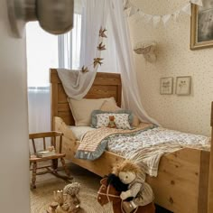 there is a small bed with two teddy bears on the bottom and an old fashioned rocking chair next to it