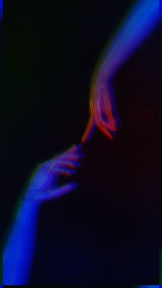 two hands touching each other in the middle of an image with blue and red light