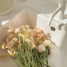 some flowers are sitting in a white sink