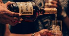 people are pouring wine into glasses at a bar