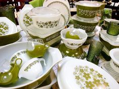 a table topped with lots of green dishes