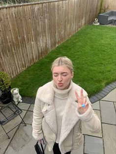 a woman making the peace sign with her fingers