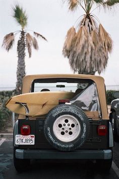 the back end of a jeep with a surfboard strapped to it's trunk