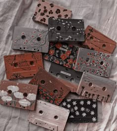 there are many different types of cassettes on the bed sheet that have been made to look like flowers