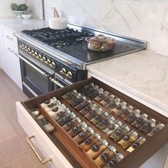 an open drawer in the middle of a kitchen with spices and condiments on it