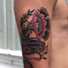 a woman's arm with a tattoo on it that has flowers and a record