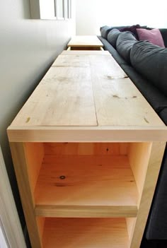 a wooden table sitting next to a black couch