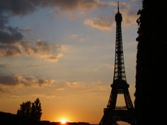 the eiffel tower is silhouetted at sunset