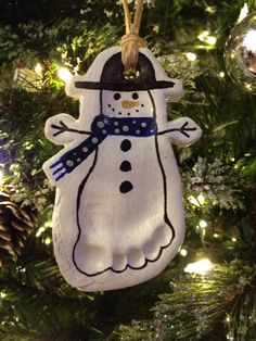 a snowman ornament hanging from a christmas tree