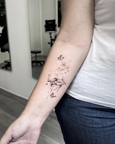 a woman's arm with a tattoo on the left side of her body and flowers in the middle