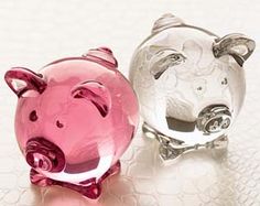 two glass pig figurines sitting next to each other