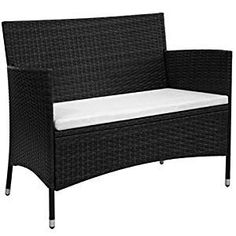 a black wicker chair with white cushions on it's back end and armrests