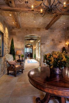 a living room filled with furniture and a chandelier above a wooden dining table