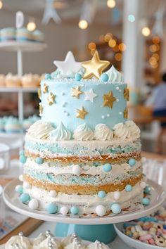 a multi layer cake sitting on top of a table next to cupcakes and cakes