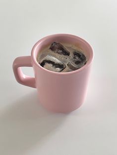 a pink coffee cup filled with ice and some type of animal on the inside of it