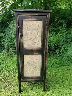 an old fashioned cabinet sitting in the grass