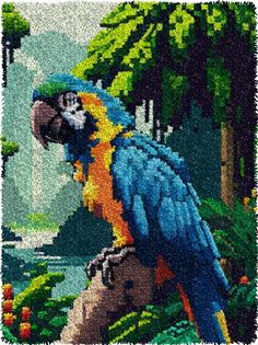 a blue and yellow parrot sitting on top of a tree branch in front of water