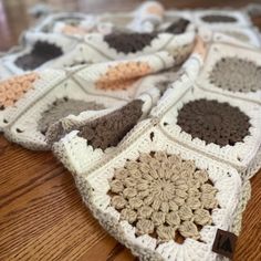 there are many crocheted squares on the table