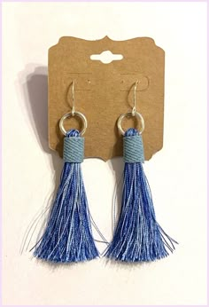 two pairs of earrings with blue tassels and silver rings on a white background