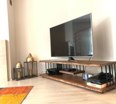 a flat screen tv sitting on top of a wooden shelf