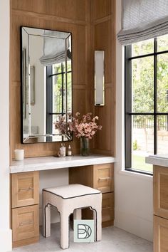 a bathroom with a vanity, stool and large mirror on the wall next to it