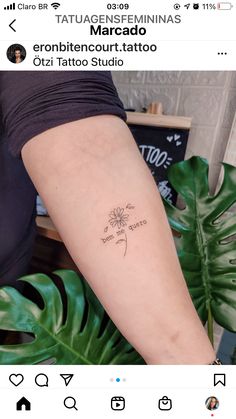 a woman's arm with a small flower tattoo on the left side of her arm