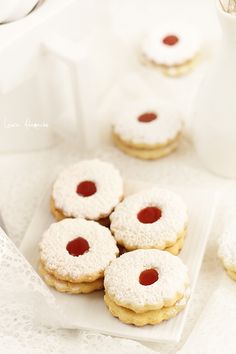 small cookies with jam on them sitting on a table