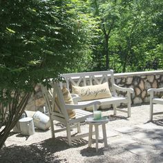 there are many chairs and tables on the patio near each other, with pillows on them