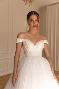 a woman in a white wedding dress posing for the camera