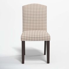 a brown and white checkered upholstered chair with dark wood legs on an off - white background