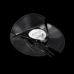 an upside down vinyl record with scissors in it's center on a black background