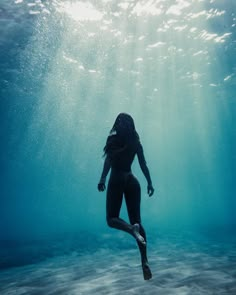 a woman is swimming in the ocean with her legs spread out to show off her body