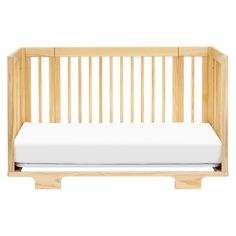 a wooden crib with a white mattress in it