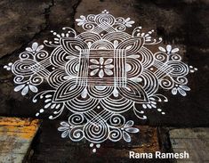 an intricate design is painted on the ground with white paint and watercolor pencils