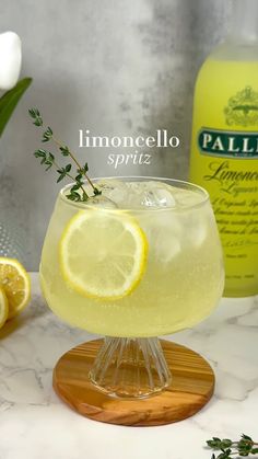 a lemonade spritz sitting on top of a table next to some flowers