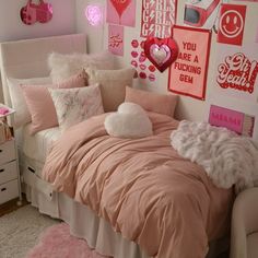 a bedroom decorated in pink and white with lots of pictures on the wall above the bed