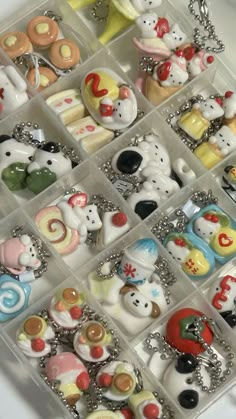 a bunch of small toy animals are in a plastic box with chain necklaces on it