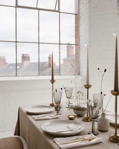 a table set with place settings and candles