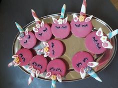 pink cupcakes with unicorn faces on them are arranged in the shape of hearts