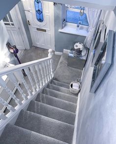 stairs leading up to the second floor in a house with grey carpet and white railings